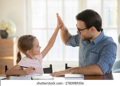 Happy little girl   father giving high five  studying at home together  smiling dad   pretty preschool girl satisfied by good homework results  homeschooling  teacher praising student