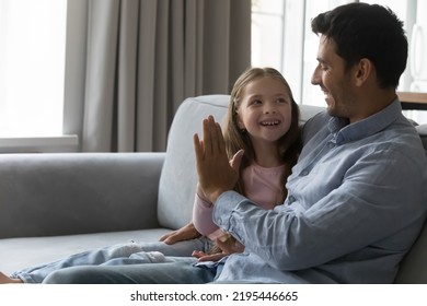 Happy Little Girl Give High Five To Hispanic Dad. Loving Father Spend Leisure Time With Daughter, Talking, Express Support, Praising With Hand Gesture, Showing Approval, Congratulate, Make Bet