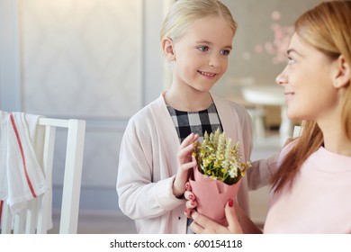 Happy Little Girl Giving Flowers To Her Mother