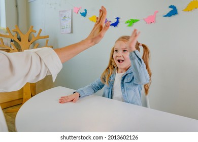 Happy Little Girl Giving High Five To Her Teacher After Good Work At Lesson