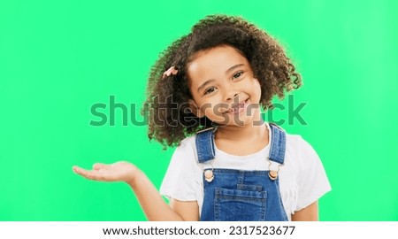 Happy, little girl and green screen with smile for product placement isolated against a studio background. Portrait of cute female kid smiling with palm of open hand showing advertisement on mockup