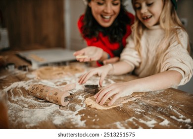 Happy little girl having fun while baking holiday cookies with her mother - Powered by Shutterstock