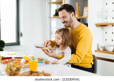 Happy little girl and her father preparing sandwiches  in the kitchen - Powered by Shutterstock
