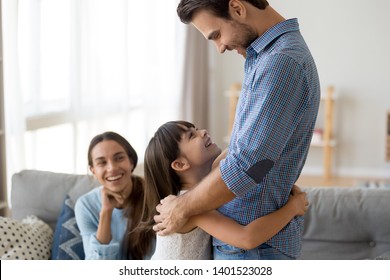 Happy Little Girl Hug Smiling Dad Come Home After Business Trip, Overjoyed Young Father Embrace Cute Preschooler Daughter Reunited With Wife After Divorce, Excited Child Cuddle With Parent Arrive