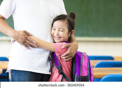 happy little Girl hugging her father in classroom
