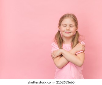 Happy Little Girl Hugging Herself On Pink Background With Copy Space. I Love Myself Consept.