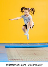 Happy little girl jumping on trampoline in fitness center - Shutterstock ID 2193407339