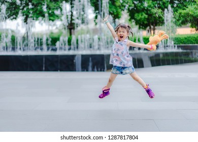 Happy Little Girl Jumping In Shopping Mall . Little Asian Girl Jumping At Shopping Mall In Thailand 2018