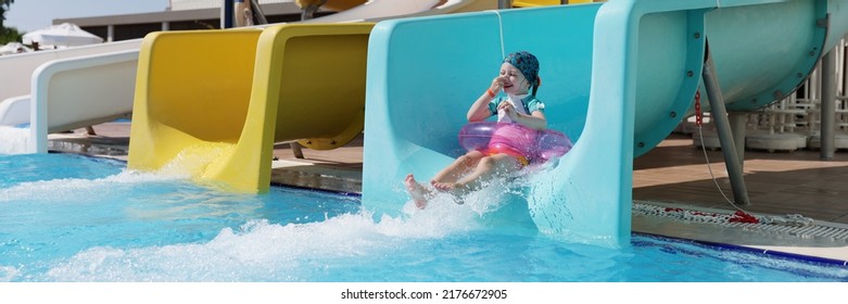 Happy Little Girl Kid Slide Down Hill On Pink Air Mattress In Water Park