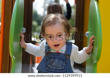 Happy little girl playing in a urban playground.