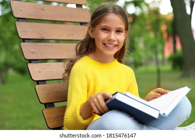 Happy little girl reading book in park  - Powered by Shutterstock