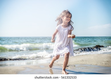 Happy Little Girl Running On The Beach