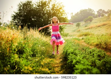 Happy little girl running on the grass. Running open arms little happy girl green meadow field track