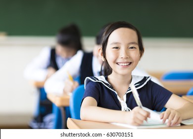 happy little girl in school with her friends in background