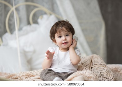 Portrait Of Happy Little Girl Sitting On Bed With Legs Crossed Kid