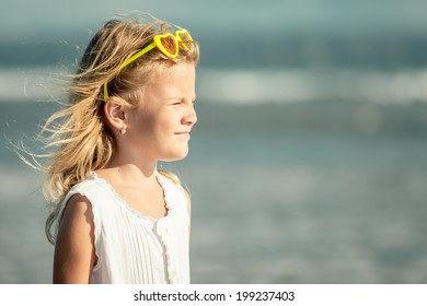 happy little girl   standing at the beach at the day time
