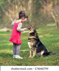 Happy Little Girl Talking To Dog