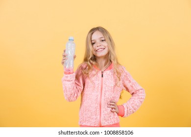 Happy Little Girl With Water From Plastic Bottle On Orange Background, Copy Space