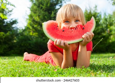 Happy Little Girl With Watermelon In A Garden