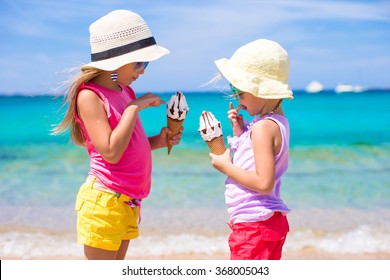 Happy little girls eating ice-cream over summer beach background. People, children, friends and friendship concept - Powered by Shutterstock