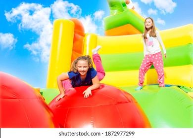 Happy little girls having lots of fun while jumping from ball to ball on an inflate castle.