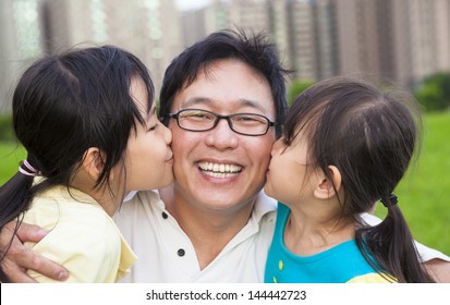 Happy Little Girls Kissing Their Father