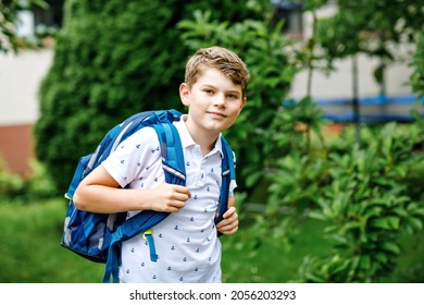 Happy Little Kid Boy With Satchel, Walking. Schoolkid On The Way To Middle Or High School. Excited Child Outdoors On School Yard. Back To School.