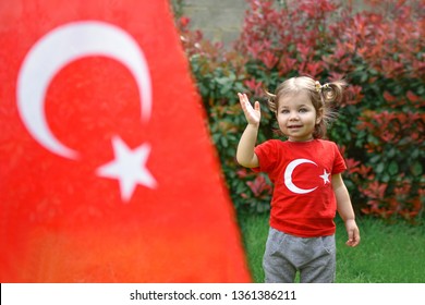 Happy Little Kid, Cute Baby Toddler With Turkish Flag T-shirt And Turkish Flag On The Front. Patriotic Holiday. Adorable Child Celebrates National Holidays.