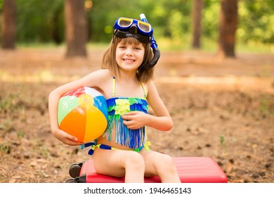 Happy Little Kid In Snorkeling Mask And Wetsuit For Dive Underwater In Sea Sits On Red Suitcase. Family Travel Lifestyle In Summer Adventure Camp. Swimming Activities On Beach Child Vacation