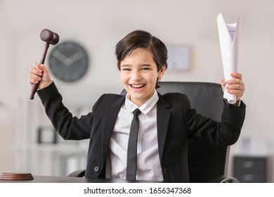 Happy little lawyer with judge gavel and document in office - Powered by Shutterstock