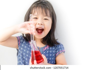 Happy Little scientist asian girl with red liquid into flask on white background. Home school girl learning about science and pouring reagent into flask.Chemistry class at home. - Shutterstock ID 1207051714