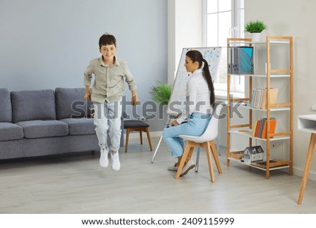 Happy little troublemaker misbehaves at a therapy session. Joyful naughty child boy jumping and having fun during a meeting with a children's therapist or psychologist. ADHD, hyperactivity concept