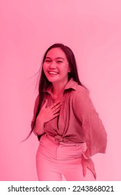 A happy and lively young asian woman posing behind a plain background. Viva Magenta tinted photo. - Shutterstock ID 2243868021