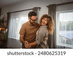 Happy in love couple man woman husband and wife dance at home have fun