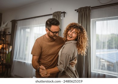 Happy in love couple man woman husband and wife dance at home have fun - Powered by Shutterstock