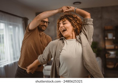 Happy in love couple man woman husband and wife dance at home have fun - Powered by Shutterstock