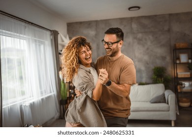 Happy in love couple man woman husband and wife dance at home have fun - Powered by Shutterstock