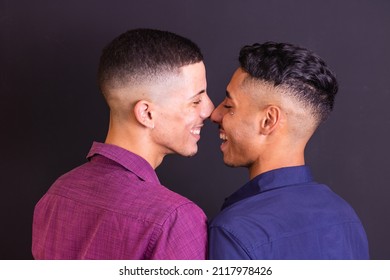 happy and in love gay dating couple kissing eskimo on black background