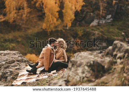 Happy in love romantic young cheerful couple man and woman married travel hiking walk together among the autumn forest and mountains looking for adventure enjoy the local nature, selective focus