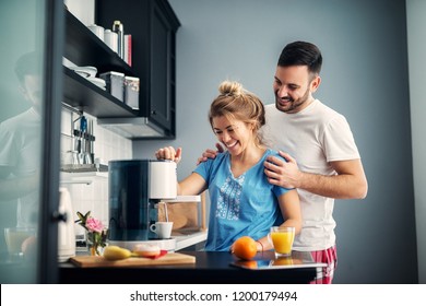 Happy In Love Young Couple Making Some Coffee In Their Kitchen.