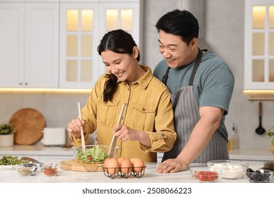 Happy lovely couple cooking together in kitchen - Powered by Shutterstock