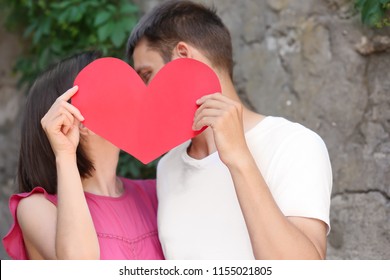 Happy lovely couple with paper heart on summer day outdoors - Shutterstock ID 1155021805