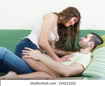 Happy loving adult couple hugging with passion on sofa in home interior - Shutterstock ID 214211332