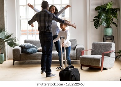 Happy Loving Black Family Wife And Kid Daughter Excited To Meet Hurry To Hug Dad With Suitcase Coming Returning Home Arriving From Long Business Trip, Welcome Back African Father, Reunion Concept