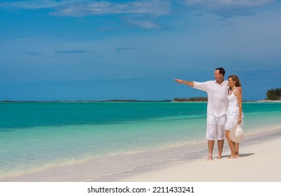 Happy Loving Caucasian Couple In White Clothing Carefree Outdoors By The Ocean On Tropical Luxury Caribbean Island Resort Barefoot 