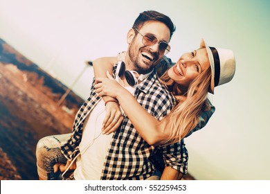 Happy Loving Couple Embracing Outdoors At Summertime Under Blue Sky.