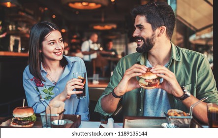 Happy loving couple enjoying breakfast in a cafe. Love, dating, food, lifestyle concept