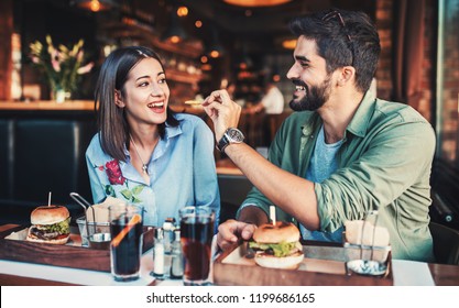 Happy loving couple enjoying breakfast in a cafe. Love, dating, food, lifestyle concept