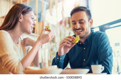 Happy loving couple enjoying breakfast in cafe. Love, food, lifestyle concept.