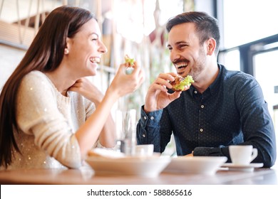 Happy loving couple enjoying breakfast in a cafe. Love, dating, food, lifestyle - Shutterstock ID 588865616
